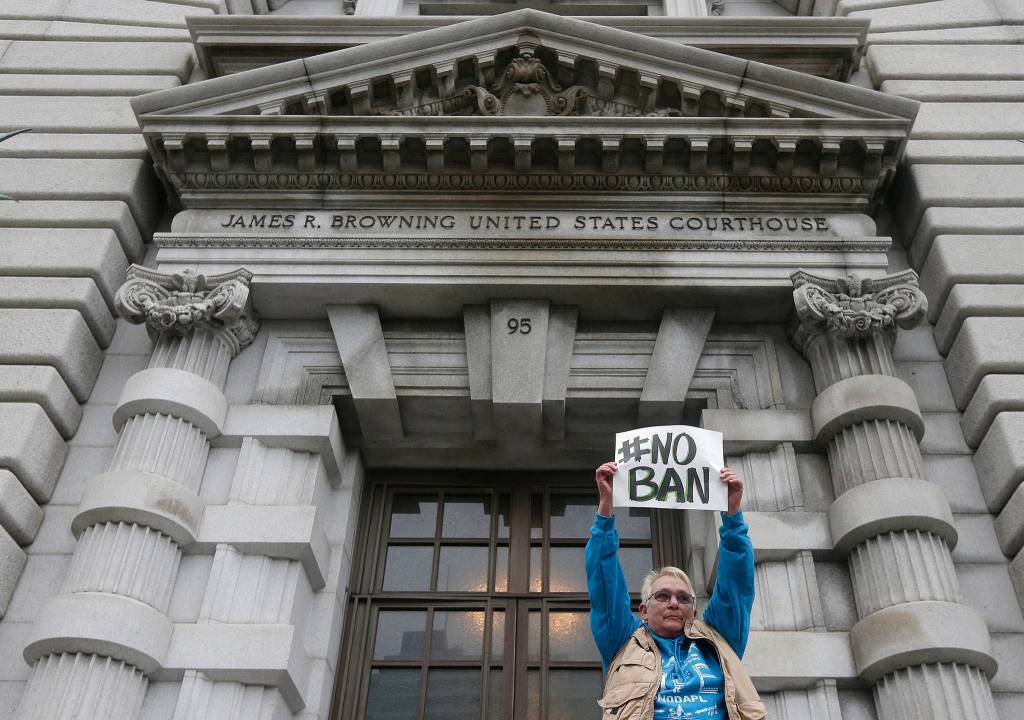 In this Feb. 7 photo, Karen Shore holds up a sign outside of the 9th U.S. Circuit Court of Appeals in San Francisco. (Jeff Chiu/The Associated Press)