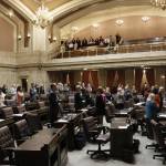 Lawmakers at the House stand during the Pledge of Allegiance on Tuesday in Olympia. The Legislature must send a new two-year budget this week or else risk a partial government shutdown. (Rachel La Corte/The Associated Press)