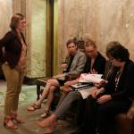 Democratic state Rep. June Robinson, standing, talks with fellow Democratic budget negotiators, Reps. Kristine Lytton and Timm Ormsby, seated right, and staff in the House wings before heading into a meeting to brief fellow lawmakers on the details of a state budget deal on Thursday in Olympia. (Rachel La Corte/The Associated Press)