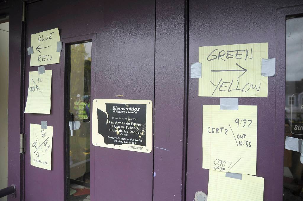 Following Saturday&rsquo;s earthquake drill in Sequim, Community Emergency Response Team members post results of their searches on the front door of Sequim Community School. (Michael Dashiell/Olympic Peninsula News Group)