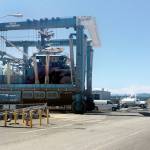A lift carries a fishing boat across the workyard at Boat Haven Marina. The yard is scheduled to be resurfaced by Sept. 1 to cut down on dust. (Cydney McFarland/Peninsula Daily News)