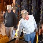 Bruce McCloskey, co-owner of B&B Family Farm, shows visitors last Sunday lavender that will go in pillows and other items. (Matthew Nash/Olympic Peninsula News Group)