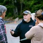 Derek Randles of the Olympic Mountain Response Team, center, talks with Jacob Gray&rsquo;s parents, Randy Gray and Laura Gray, before the search for their son Saturday. (Jesse Major/Peninsula Daily News)