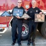 Port Angeles firefighters Mel Twitchell, left, and Pete Sekac, right, were honored with flags at their retirement ceremony Friday morning. (Patti Reifenstahl)