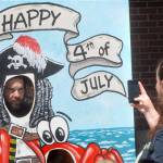 Kenneth Emerson of Port Angeles poses as a pirate as his wife, Sarah Emerson, takes a photo with her cellphone during Independence Day festivities at The Gateway transit center pavillion in Port Angeles. (Keith Thorpe/Peninsula Daily News)