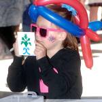 Katrina Peterson, 7, of Port Angeles shows off a ceramic tile she decorated at a kids activity center on Independence Day at The Gateway transit center pavillion in Port Angeles. (Keith Thorpe/Peninsula Daily News)
