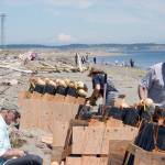 Bob Frampton, left, Bill Stabile, right, and head pyrotechnician David Chuljian, back, set up a fireworks display on the beach at Fort Worden for the third annual Old School 4th of July celebration. (Cydney McFarland/Peninsula Daily News)
