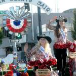 Clallam County Fair Princess Marykate Napiontek, left, and Queen Janeydean O&rsquo;Connor wave to the crowd in Tuesday&rsquo;s Fourth of July Parade in Port Angeles. Their parade entry took top honors for outstanding float. (Keith Thorpe/Peninsula Daily News)