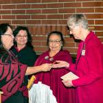 Priscilla Hudson receives a cedar strip from Medicine Woman Marie Riebe as daughter Judy Cathers and Quileute tribal member Vince Penn look on. The strip was given to Hudson for her research and discovery of the canoe&rsquo;s owner, Viola Riebe, second from right.