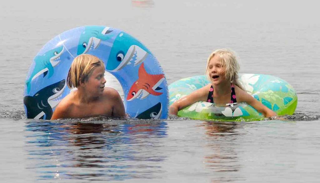 Curren Mehew, 8, and his sister, Penelope Mehew, 4, both of Port Angeles, beat the heat while floating at East Beach in Lake Crescent in Olympic National Park on Wednesday. Temperatures ranging from the upper 70s to mid-90s were expected across the North Olympic Peninsula through Saturday. (Keith Thorpe/Peninsula Daily News)
