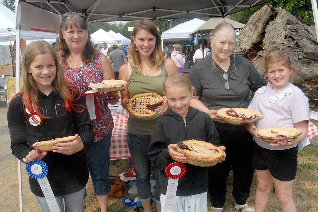 Winners of the annual Joyce Daze Wild Blackberry Festival gather after the competition. The youth winners were, front row from left, Lauren Stephens, 11, of Portland, Ore., first place; Lily Robertson, 9, of Joyce, second place; and Ariana Varholla, 9, of Port Angeles, third place. In the adult competition the top finishers were all from the Joyce area. From left are Katy Thompson, second place; Ashlyn Anderson, first place; and Joan Rogers, third place. (Keith Thorpe/Peninsula Daily News)