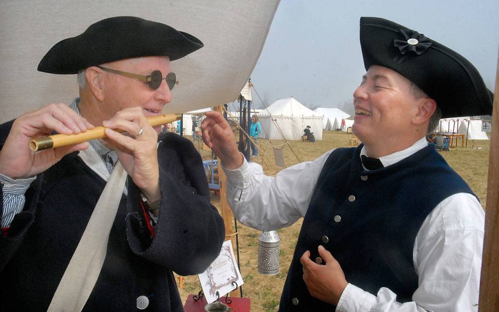 Larry Barnes of Graham takes a lesson in fife playing from Linda Soule of Bellingham on Friday at a colonial village set up on the lawn of the George Washington Inn near Agnew, the site of the 2017 Northwest Colonial Festival. (Keith Thorpe/Peninsula Daily News)
