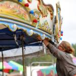 Amber Guy with Rainier Amusement of Portland, Ore., helps set up the merry-go-round at the Clallam County Fair on Monday. (Matthew Nash/Olympic Peninsula News Group)