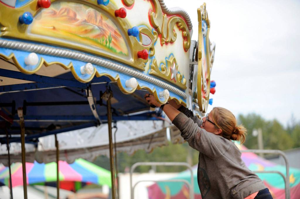Amber Guy with Rainier Amusement of Portland, Ore., helps set up the merry-go-round at the Clallam County Fair on Monday. (Matthew Nash/Olympic Peninsula News Group)