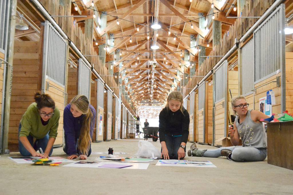 Members of the Silver Spurs 4-H Club &mdash; from left, Ashlyne Money, 16; Sierra Steffen, 12; Marissa Steffen, 10; and Lisi Hanson, 15 &mdash; design posters for their horses&rsquo; stalls Monday in a horse barn at the Clallam County Fairgrounds. Their group will show 18 horses throughout the fair, which runs through Sunday. (Matthew Nash/Olympic Peninsula News Group)