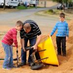 Jeff Bender, with help from his sons Daniel, 9, left, and Grant, 8, right, tries to fix a flat tire on a wheelbarrow outside the swine barn at the Clallam County Fair. Daniel belongs to Pure Country 4-H and will show pigs, rabbits and goats throughout the fair. (Matthew Nash/Olympic Peninsula News Group)