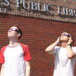 Port Angeles residents Jesse Driese, 14, and James Saskowsky, 13, try out eclipse glasses at the Port Angeles Library. On Monday, the library will hand out about 50 glasses for its solar eclipse event on a first-come, first-served basis. (David Logan/for Peninsula Daily News)