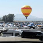 A hot air balloon rises over Solartown, an encampment serving as a temporary home to tens of thousands of eclipse watchers Sunday morning in Madras, Ore. The site is located at the center of the swath of shadow of a total solar eclipse today that will trace a path from Oregon to South Carolina. (Keith Thorpe/Peninsula Daily News)