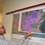 Sequim Assistant City Manager Joe Irvin holds maps of different regions in the city of Sequim on which staff members hope residents, churches and business owners will help them pinpoint issues and opportunities in their areas at a Neighborhood Visioning Meeting on Saturday in the Guy Cole Center. (Matthew Nash/Olympic Peninsula News Group)