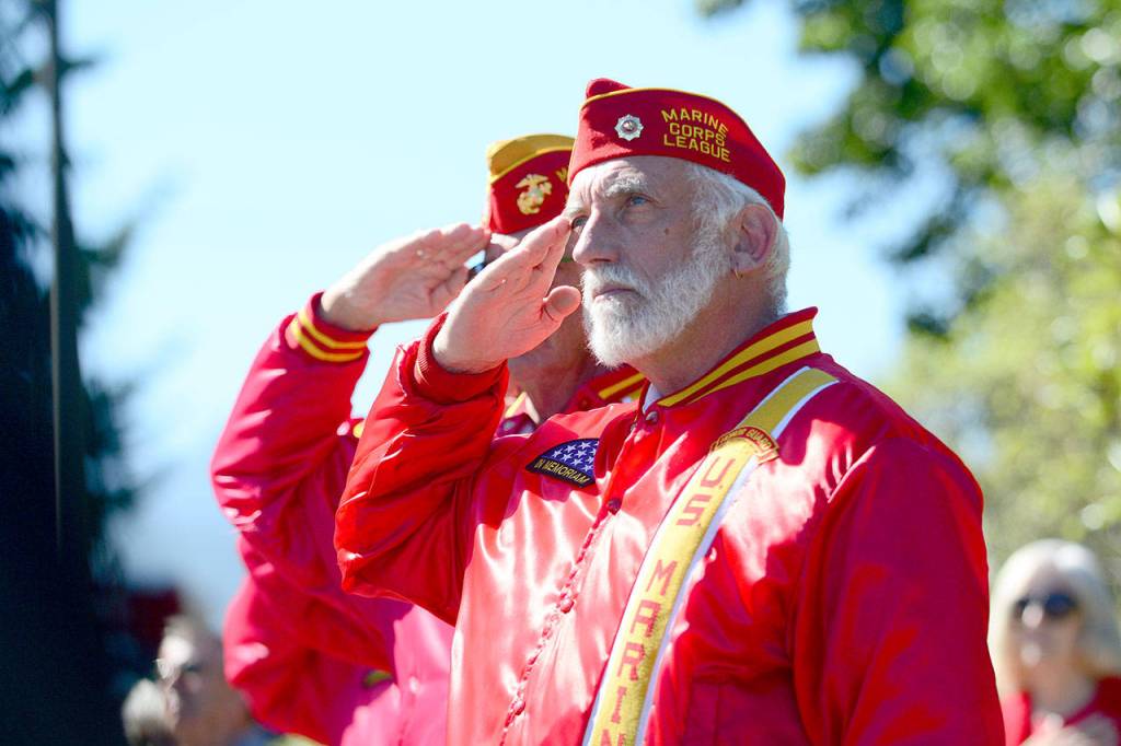 Bob Nicholls of the Mt. Olympus Detachment of the Marine Corps League salutes as an American flag is raised during a ceremony at the 9/11 Memorial Waterfront Park Monday in Port Angeles. (Jesse Major/Peninsula Daily News)