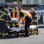 Emergency workers assist a pedestrian after the person was struck by a vehicle at the intersection of First and Race streets in Port Angeles on Tuesday. (Keith Thorpe/Peninsula Daily News)