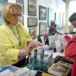 Port Townsend Film Festival volunteer Kathleen Holt hands out passes to Anne Virtue and Patrick Roach of Port Townsend, who are attending the festival for the first time this year. (Cydney McFarland/Peninsula Daily News)