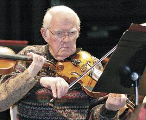 Paul Cornaby plays his violin during a rehearsal of Glazounow&rsquo;s &ldquo;Valse De Concert&rdquo; at Port Angeles High School in December 2009. (Peninsula Daily News)