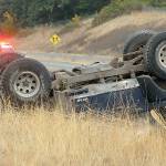 Keith Thorpe/Peninsula Daily News Washington State Patrol troopers Matthew Phillips, left, and Eric Ellefson investigate the scene where a Jeep rolled over on the side of the U.S. Highway 101 exit ramp to River Road in Sequim on Friday.