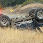 Washington State Patrol Troopers Matthew Phillips, left, and Eric Ellefson investigate the scene where a Jeep rolled over on the side of the U.S. Highway 101 exit ramp to River Road in Sequim on Friday. (Keith Thorpe/Peninsula Daily News)