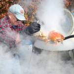 Julian McCabe helps pull cooked crab from a kettle on its way to the plate of a hungry festivalgoer in 2016. (Keith Thorpe/Peninsula Daily News)