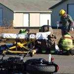 Emergency responders tend to a motorcyclist who sustained leg injuries in a wreck in Sequim on Tuesday. (Erin Hawkins/Olympic Peninsula News Group)