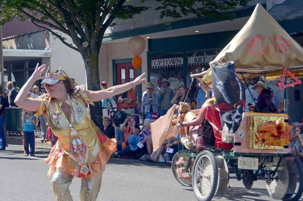Caption 2: Kelly Bell of Kinetic Sculpture team IPA dances in the Uptown Street Fair in Port Townsend. (Cydney McFarland/Peninsula Daily News)