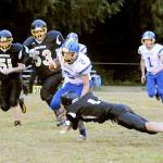 Lonnie Archibald/for Peninsula Daily News                                Crescent&rsquo;s Robert Cox (2) is stopped by Clallam Bay&rsquo;s Ryan Strid (1) Friday in Crescent&rsquo;s 68-27 win. Also in on the action are Bruins Anthony McGraw (51) and Eric Strid (53). Crescent&rsquo;s Fischer Hartley (1) trails the play.