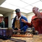 Members of the North Olympic Peninsula Railroaders &mdash; from left, Steve Stripp, John Kumparak and Pat Furey &mdash; discuss trains and the upcoming show for the club, set Saturday and Sunday at the Sequim Prairie Grange. (Matthew Nash/Olympic Peninsula News Group)
