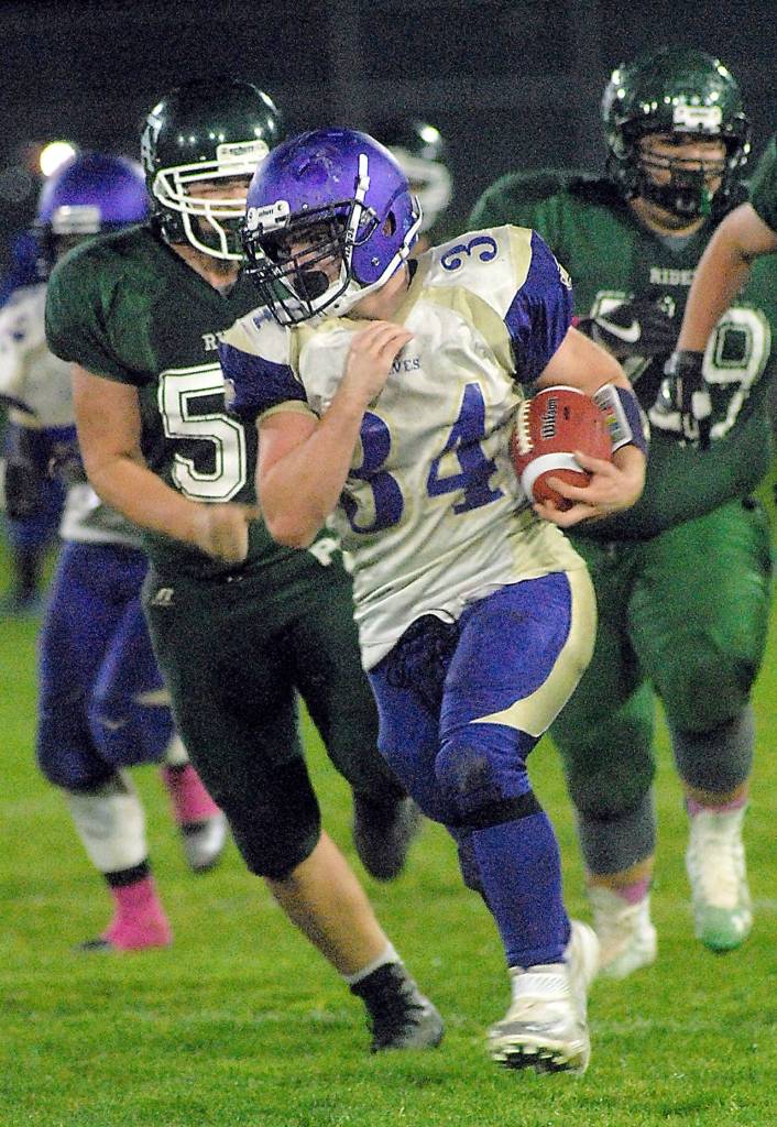 Keith Thorpe/Peninsula Daily News Sequim&rsquo;s Tyler Conn, center, evades the defense of Port Angeles&rsquo; Cyrus Johnson, left, and TeeJay Johnson during the fourth quarter on Friday night at Port Angeles Civic Field.