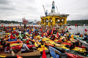 Activists in kayaks and other vessels who oppose Royal Dutch Shell's plans to drill for oil in the Arctic Ocean mass near Shell's Polar Pioneer drilling rig in Seattle's Elliott Bay on Saturday. (The Associated Press (CLICK on photo to enlarge))