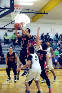 Neah Bay's Abraham Venske (3) puts up a shot against the defense of Clallam Bay's Kelly Gregory and Alan Greene (3) while Neah Bay's Ryan Moss (24) prepares to block out. Also in on the play are Neah Bay's Jongi Claplanhoo (20) and Clallam Bay's Sam Signor