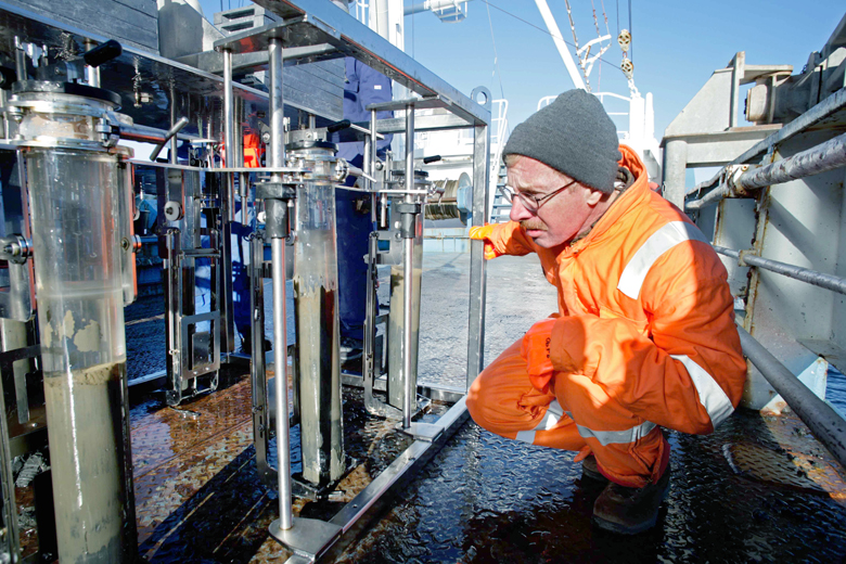 Paul Loubere is pictured on the deck of the research vessel Lance in a fjord along the northern coast of Svalbard in the Arctic. He is checking a device that takes samples of ocean floor sediment. (Jefferson County Library)