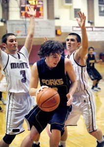 Forks' Billy Palmer looks for an escape route against a pair of Montesano defenders. (Lonnie Archibald/for Peninsula Daily News)