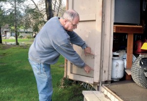 Brinnon resident Bob Shadbolt compares the water level from this month's flooding to previous high levels in December and in 2007. (Charlie Bermant/Peninsula Daily News)