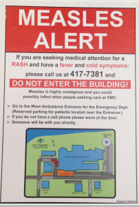 Poster at the entrance to Olympic Medical Center in Port Angeles.  An isolation tent is in a hospital parking lot. ()