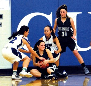Port Angeles' Brennan Gray holds the ball while looking to make a pass against Liberty defenders Presley Sweeney
