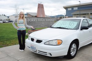 Forks senior Brooke Jacoby shows a 2004 Pontiac Grand Am donated by Wilder Auto of Port Angeles to the Forks High School Scholarship Auction