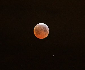The full moon turns red and orange over Port Angeles this morning. The total lunar eclipse was the third in a series of four “blood moons.” (Jay Cline (click on photo to enlarge))