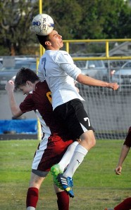 Sequim's Thomas Winfield goes up and over Kingston's Brady Vernik for a header during the first half of the Wolves' 2-0 loss at Sequim High School. (Keith Thorpe/Peninsula Daily News)