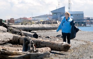 Lori Taylor of Port Angeles looks for litter and debris along Ediz Hook on the shore of Port Angeles Harbor during Saturday's beach cleanup event. (Keith Thorpe/Peninsula Daily News)