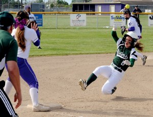 Port Angeles' Sierra Robinson (6) reaches third base safely as Sequim's Chloie Sparks awaits the throw and Port Angeles coach Randy Steinman