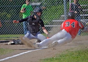 Quilcene catcher A.J. Prater tags out Oakville's Alex Youcktan as he slides into home during the Class 1B Quad-District playoffs on Friday. The Rangers lost to the Acorns 8-0 on Friday and then were eliminated from the postseason with a 8-5 loss to Shoreline Christian at Muckleshoot Tribal School on Saturday. (Steve Mullensky/for Peninsula Daily News)