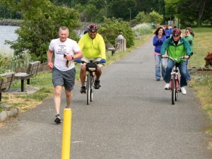 Tom Wahl runs toward the finish line of the North Olympic Discovery Marathon on Saturday near City Pier in Port Angeles. Buddy Bear