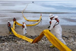 Workers prepared a containment boom Thursday after an oil spill fouled the waters off Refugio State Beach. (The Associated Press)